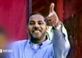 Omar al-Bayoumi in a blue shirt appears to make a gun sign with his hand