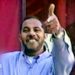 Omar al-Bayoumi in a blue shirt appears to make a gun sign with his hand