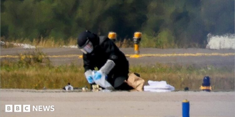 A blurred image of a man defusing a bomb on an airport runway