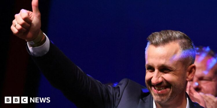 Ulrich Siegmund, leader of the AfD in the state, raises a thumbs up at the election party.