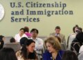 People wait inside a USCIS office as the agency changes its asylum adjudication process