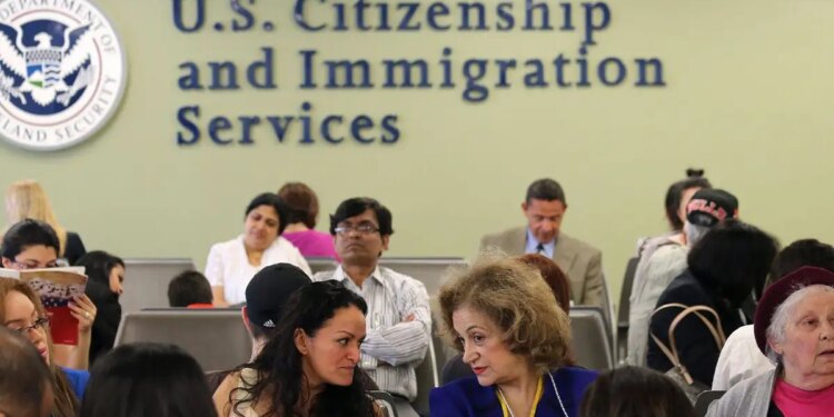 People wait inside a USCIS office as the agency changes its asylum adjudication process