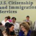 People wait inside a USCIS office as the agency changes its asylum adjudication process