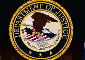 U.S. Department of Justice logo displayed on a podium.