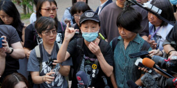 Journalists surround Medina Chow Lau Wah-chun and Elizabeth Tang Yin-ngor outside West Kowloon Law Courts Building in Hong...