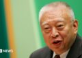Tung Chee-hwa wearing a dark suit and white shirt