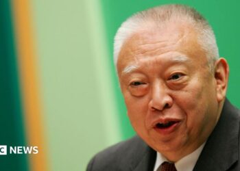 Tung Chee-hwa wearing a dark suit and white shirt