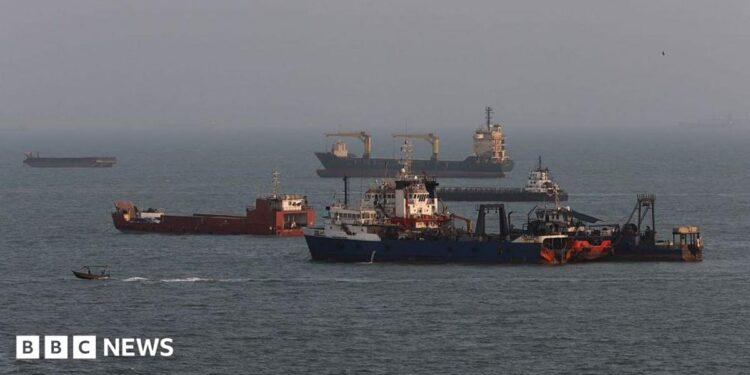 A black and white still from US footage of a tanker being hit with 'unclassified' written in green along the top