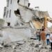 Men look at an excavator working at the site of an Israeli strike in Arab Salim, southern Lebanon