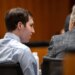 Tyler Robinson and Kathryn Nester sitting at a table with their backs to the camera in a courtroom setting.