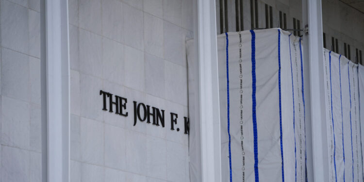 Tarp remains surrounding scaffolding after the removal of letters from the facade of the John F. Kennedy Memorial Center f...