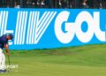 Golfer Bryson DeChambeau putts in front of a big blue and white LIV Golf sign