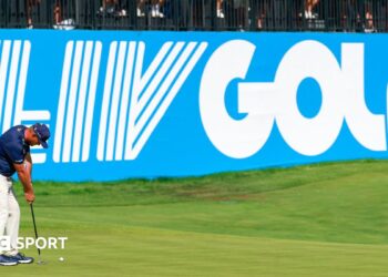 Golfer Bryson DeChambeau putts in front of a big blue and white LIV Golf sign