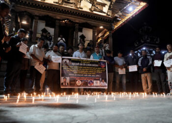 People observe a moment of silence as they gather at the Basantapur Durbar Square to mark a national mourning day in Kathm...