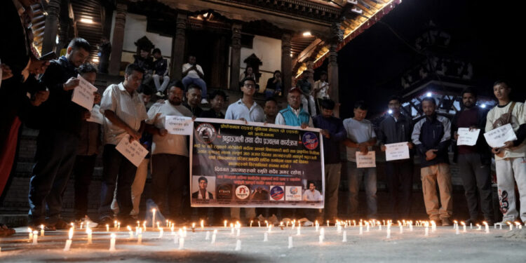 People observe a moment of silence as they gather at the Basantapur Durbar Square to mark a national mourning day in Kathm...