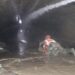 Nepalese rescuers wading through puddles of water in the Trishuli 3A tunnel