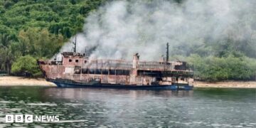 A fresh photo shared by the PCG showing a burned, smoking vessel