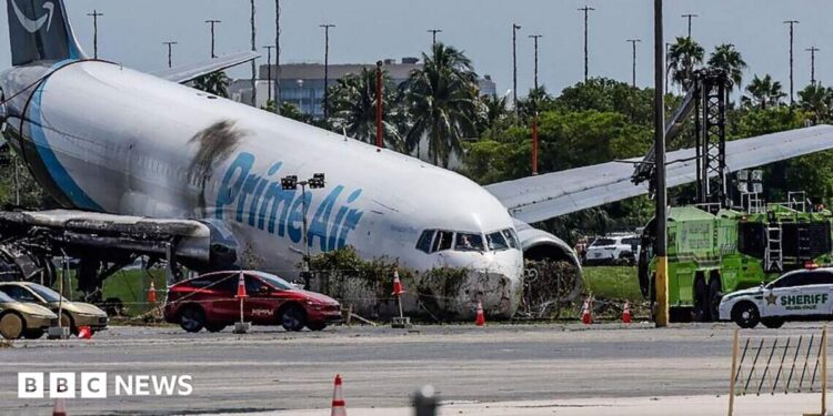 Crews investigate the site of an Amazon cargo plane crash at Miami International Airport on 8 September