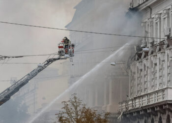 Firefighters work at a site of a building of the headquarters of Ukraine's SBU security service after a Russian drone stri...
