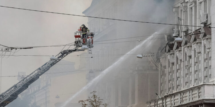 Firefighters work at a site of a building of the headquarters of Ukraine's SBU security service after a Russian drone stri...