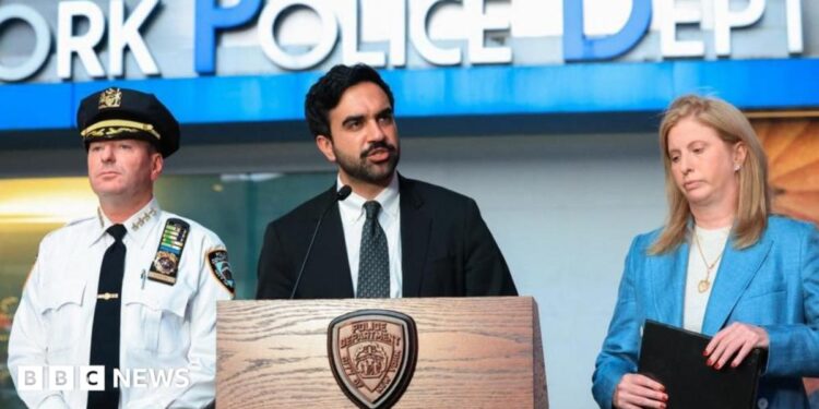 A woman with long brown hair looks at someone off-camera