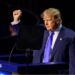 Trump wearing a blue suit and tie and white shirt opens his arms as he addresses the convention in Dallas