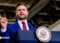 US Vice-President JD Vance speaks behind a lectern