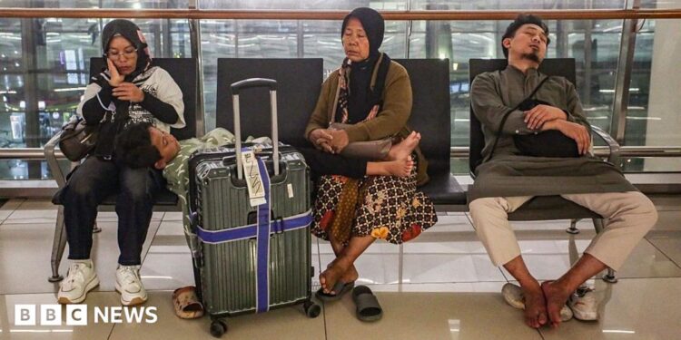 Stranded passengers rest on a bench at Soekarno-Hatta Airport in Tangerang on September 6, 2026