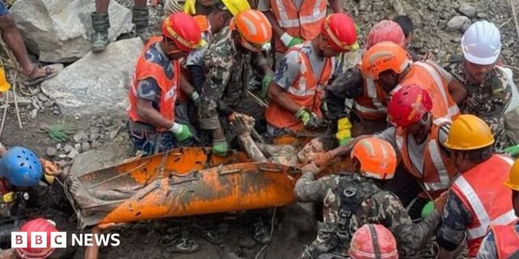 A group of rescuers holding a man on an orange stretcher.