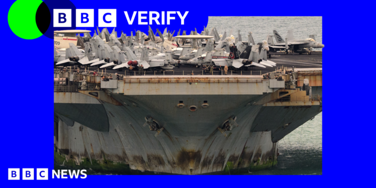 A photo of the the bottom half of the USS Lincoln with rust and algae on it, with war planes on top of the deck.