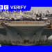 A photo of the the bottom half of the USS Lincoln with rust and algae on it, with war planes on top of the deck.