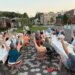Community members raise their arms during a gratitude poem at a supper in Westbrook, Maine, in July 2025 [Courtesy of Community Plate]