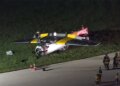 first responders stand near the overturned aircraft