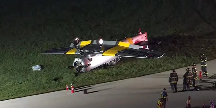 first responders stand near the overturned aircraft