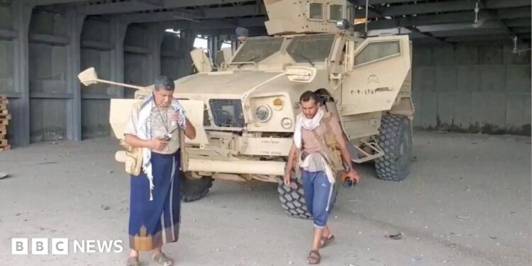 Screengrab of a video from Houthi-run Al Masirah TV showing an armed man walks next to an armoured vehicle in Mocha, Yemen, after the Houthis reportedly seized the Red Sea port city (10 September 2026)